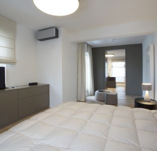 Schlafzimmer mit Boxspringbett und Sideboard grau